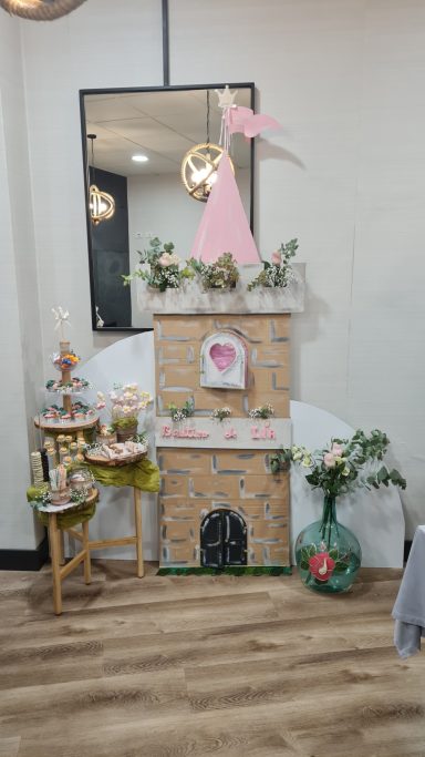 Decoración de chimenea con detalles florales y una figura rosa en el centro.